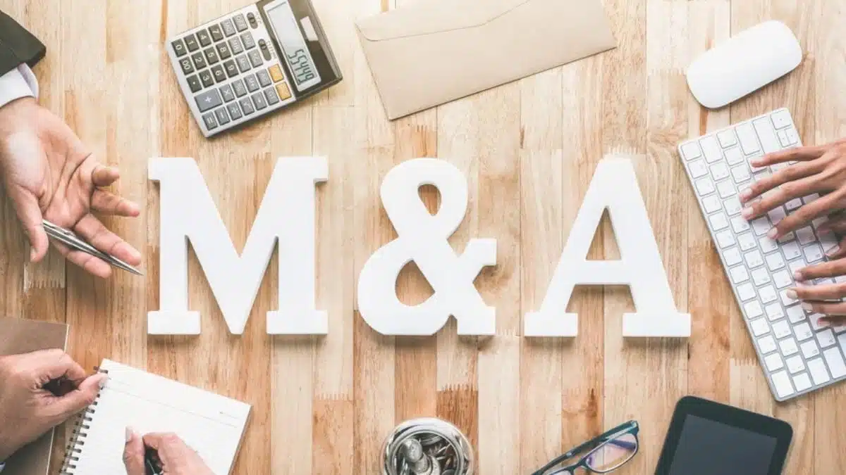 M and A in larger letters on a desk during a meeting